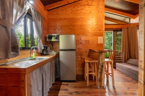 eine Küche mit einem Kühlschrank und einem Waschbecken in einer Hütte in der Unterkunft Cabaña El Manzano: Vistas increíbles y Mirador in Turrialba