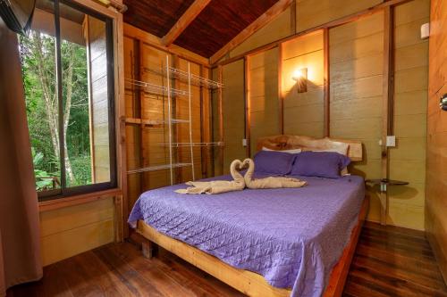 Un dormitorio con una cama con dos animales. en Cabaña El Manzano: Vistas increíbles y Mirador en Turrialba