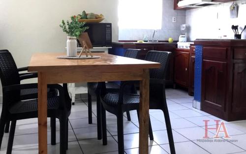 een keuken met een houten tafel en stoelen bij Hospedaje Aldana - Casa LA VISTA en zona verde in Tuxpan de Rodríguez Cano