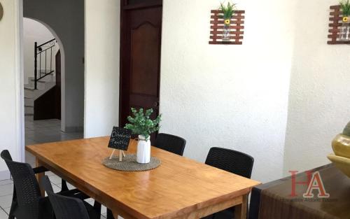 a dining room table with a vase of flowers on it at Hospedaje Aldana - Casa LA VISTA en zona verde in Tuxpan de Rodríguez Cano