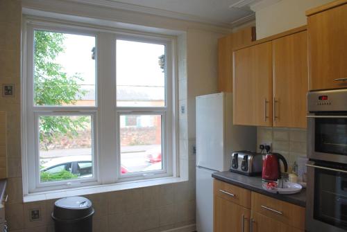 a kitchen with a window with a car outside at Clift Guest House in Bristol