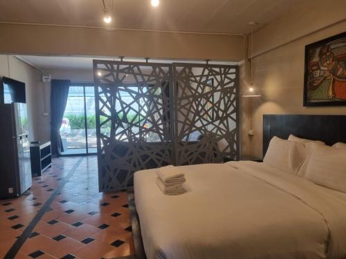 a bedroom with a large white bed and a doorway at New Breakers Hotel Rawai in Rawai Beach