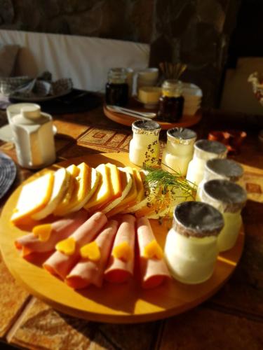 a plate of fruit and cheese on a table at Conacul Malul Alb in Râmnicu Vâlcea