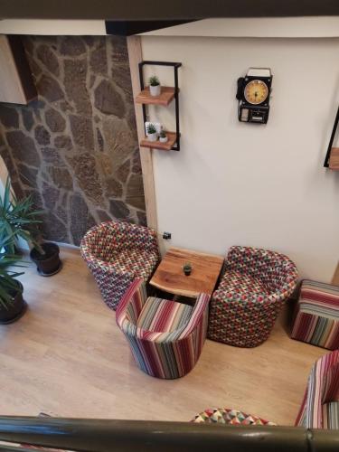 a living room with a table and chairs and a clock at UB Prenociste in Vranjska Banja