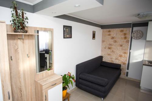 a living room with a black chair in a room at Apartments Vukman in Trogir