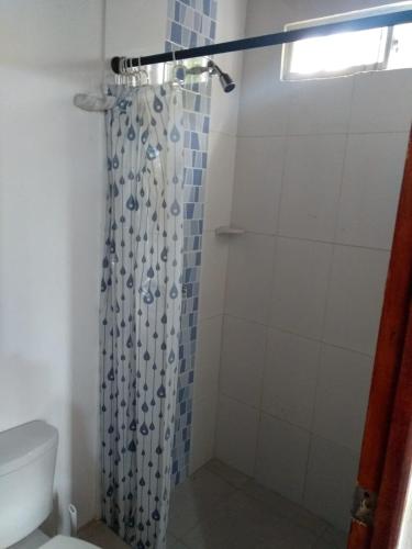 een badkamer met een douchegordijn en een toilet bij Cabañas Mayarena in San Antero