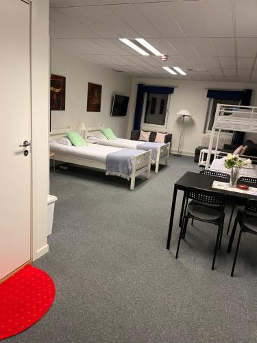 a room with two beds and a table and chairs at Route 154, 15 min till Ullared in Älvsered