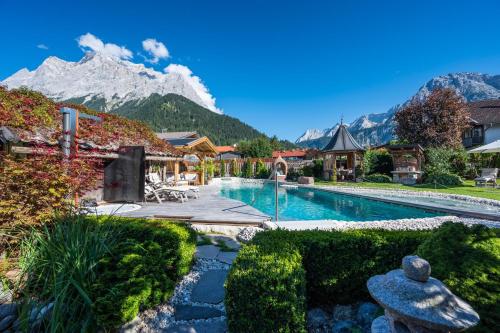 a resort with a swimming pool with a mountain in the background at Chalet Bucher in Ehrwald