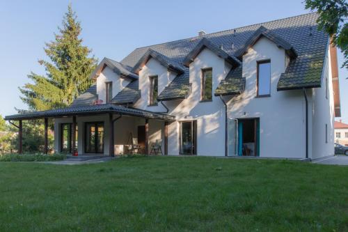 ein großes weißes Haus mit einem grünen Hof in der Unterkunft Gościniec Szpakówka in Czeremcha