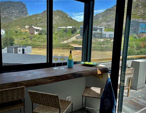 a window with two wine glasses on a counter at Prinia on Peak in Pringle Bay in Pringle Bay