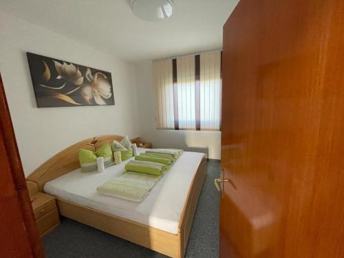 Glamočani的住宿－Bijeli Cvijet，一间卧室配有一张带绿色枕头的床