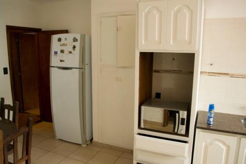 a kitchen with a white refrigerator and a microwave at Santa Cruz 5761 in Mar del Plata