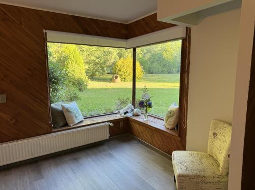 a room with a large window and a chair in front of it at Magnolia Bed & Breakfast in Villarrica