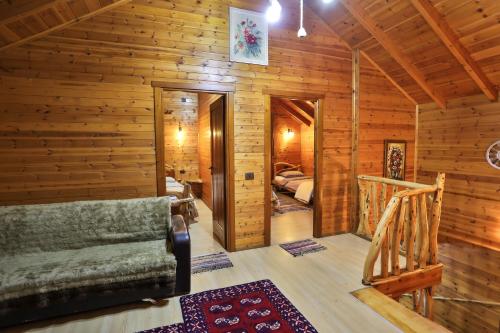 a log cabin with a couch and a bedroom at Shtepia Tradites Gjinar in Elbasan