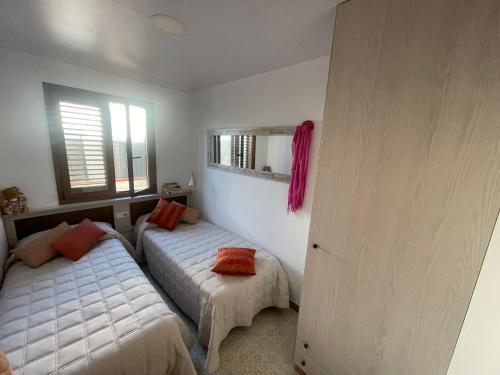 Apartament Tere في أوليفا: غرفة نوم بسريرين ونافذة