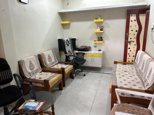 a room with chairs and a table and a desk at Varsha's Villa A Luxurious Stay. in Nagpur