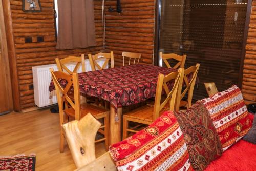 a dining room with a table and chairs in a cabin at Shtepia Tradites Gjinar in Elbasan