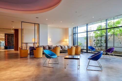 a lobby with chairs and tables in a building at Hilltop Resort Fukuoka in Fukuoka