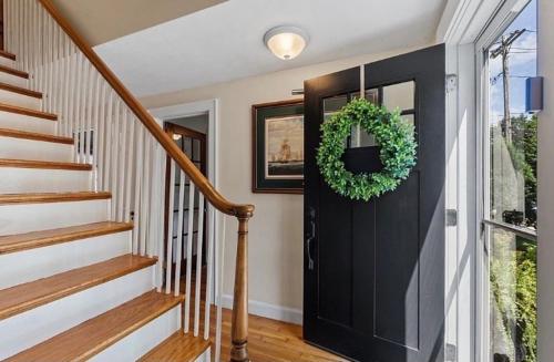 a hallway with a black door with a wreath on it at Private Bedroom in a Single House at Framingham center in Cranston