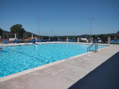 a large swimming pool with blue water at Secluded Lakeview retreat by Eureka Springs-CANOE in Eureka Springs
