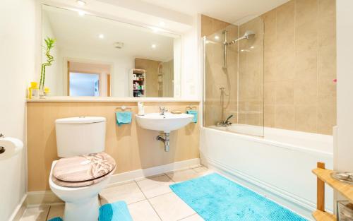 a bathroom with a toilet and a sink and a tub at 1 bedroom stylish apartment in zone 2 close to center - whole apartment in London