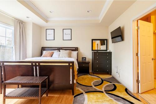ワシントンにあるLuxurious and Cozy Room in Washington DCのベッドルーム(ベッド1台、テレビ、ラグ付)