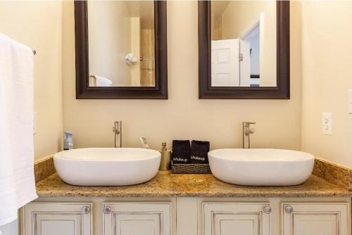 two sinks in a bathroom with two mirrors at Luxurious and Cozy Room in Washington DC in Washington