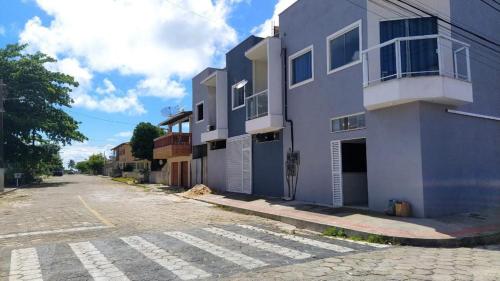 an empty street in front of a blue building at Casa Conceição da Barra temporada e Carnaval in Conceição da Barra