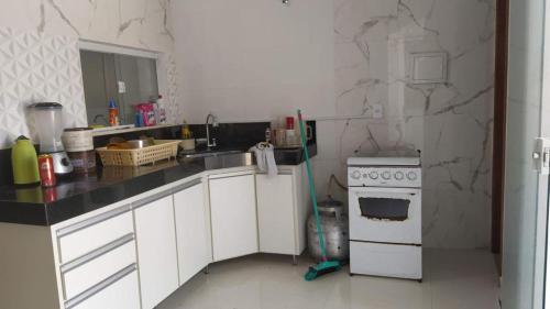 a kitchen with a sink and a stove at Casa Conceição da Barra temporada e Carnaval in Conceição da Barra