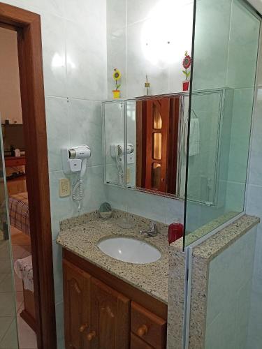 a bathroom with a sink and a glass shower at Casa Azul em Búzios in Búzios