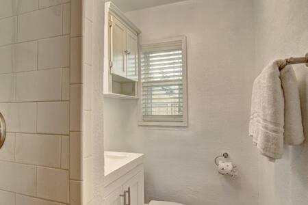 a white bathroom with a toilet and a sink at Spanish Village Siesta Villa in Port Aransas