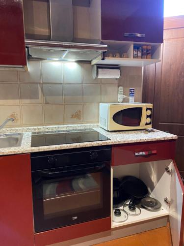 a small kitchen with a microwave and a stove at Appartamento Homemade in Biella