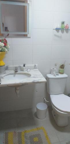 Baño blanco con aseo y lavamanos en Apartamento mobiliado, en Salvador