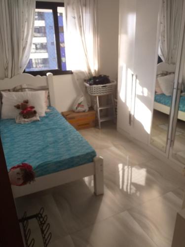 Habitación pequeña con cama y ventana en Apartamento mobiliado, en Salvador