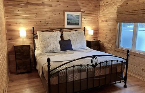a bedroom with a bed with wooden walls and a window at Domaine Summum in Mont-Tremblant