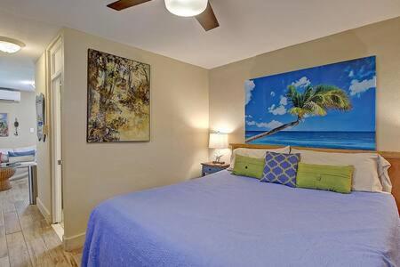 Un dormitorio con una cama y un cuadro en la pared. en Spanish Village Cottage w private cabana, en Port Aransas