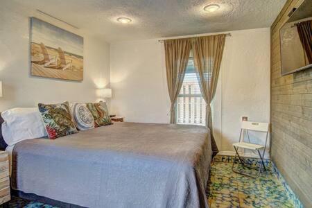Un dormitorio con una cama grande y una ventana. en Spanish Village Sunshine Cottage, en Port Aransas