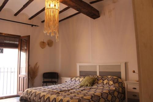 una camera con letto e lampadario a braccio di Alojamiento turistico LaVid a Requena