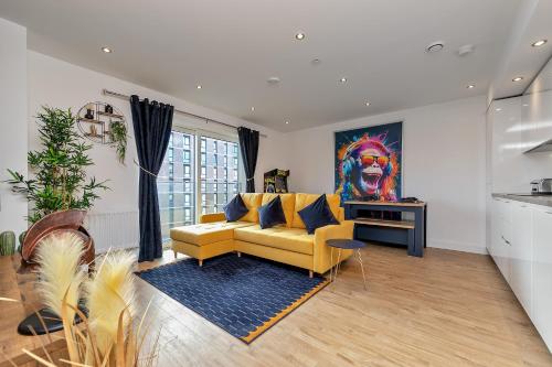 a living room with a yellow couch and a painting at Luxury Apartment-Free Parking-Central Location-Close To Airport, Station & Centre in Luton