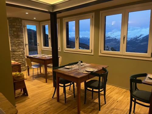 a dining room with a table and chairs and windows at Ca' De Sass in Pila