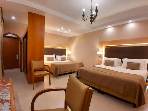 a hotel room with two beds and a chandelier at Montespina Park Hotel in Naples