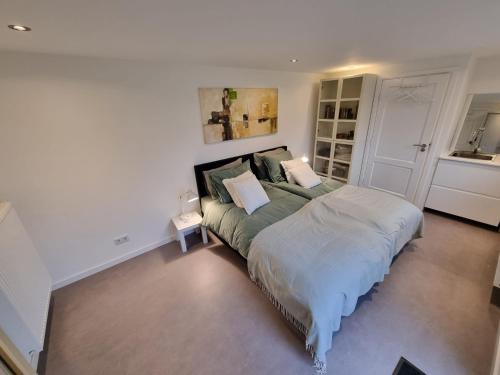 a bedroom with a large bed in a room at Zelfstandig gastenverblijf in het groene Haren nabij Groningen in Haren