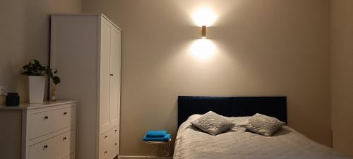 a bedroom with a bed and a light on the wall at Gościniec Szpakówka in Czeremcha