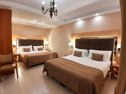 a hotel room with two beds and a chandelier at Montespina Park Hotel in Naples