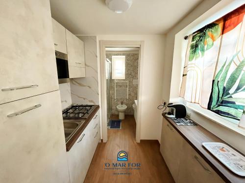a kitchen with a sink and a stove top oven at O' MAR FOR casa vacanza in Bacoli