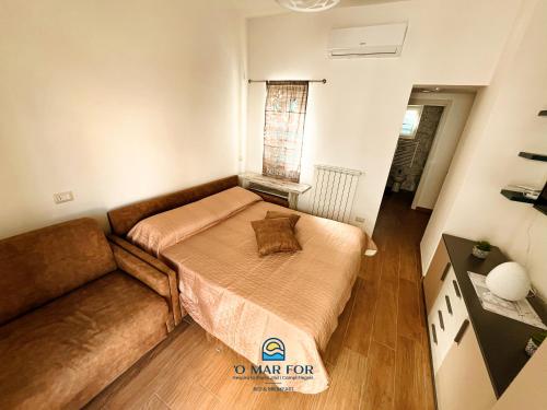 a small bedroom with a bed and a couch at O' MAR FOR casa vacanza in Bacoli
