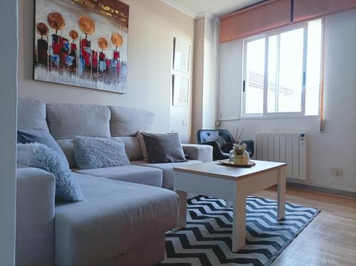 a living room with a couch and a table at Apartamento Sobreira en centro Allariz con WIFI in Allariz