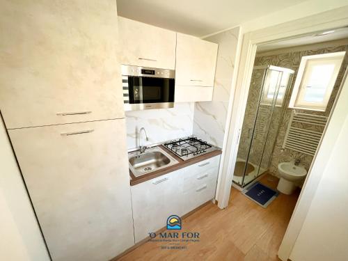 a small kitchen with a sink and a stove at O' MAR FOR casa vacanza in Bacoli