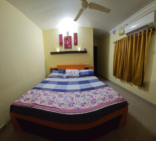 a bedroom with a bed with a blue and white comforter at Joys Stay in Trichūr