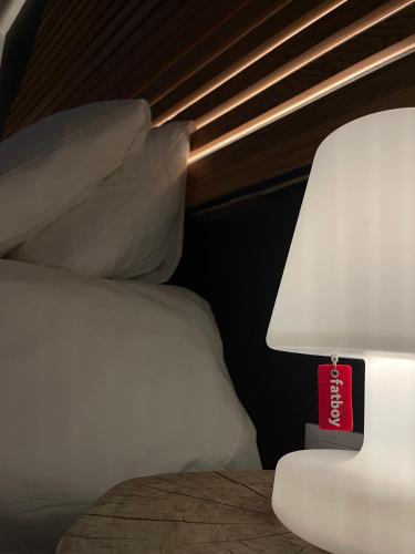a bed with a white pillow and a red lamp at Ca' De Sass in Pila
